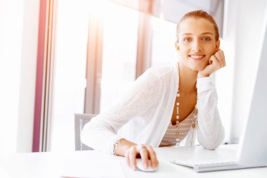 Çekici ofis çalışanı masada oturuyor.