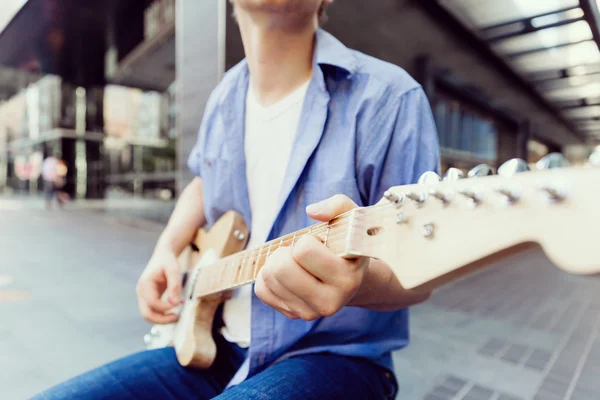 Молодий музикант з гітарою в місті — стокове фото