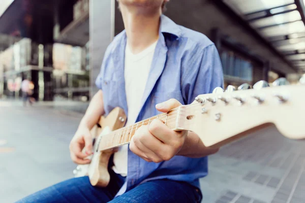 Joven músico con guitarra en la ciudad — Foto de Stock