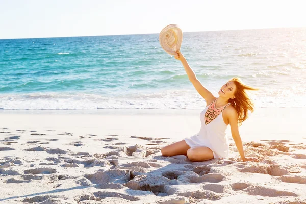 Ung kvinna sitter på stranden — Stockfoto