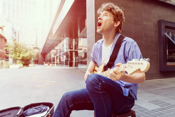 Young musician with guitar in city — Stock Photo, Image