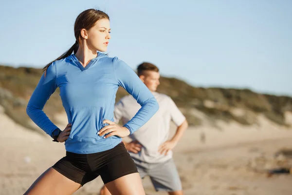 Jeune couple sur la plage d'entraînement ensemble — Photo