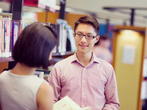 Twee jonge studenten in de bibliotheek — Stockfoto