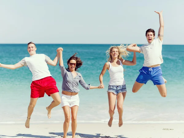 Gezelschap van jonge mensen op het strand — Stockfoto