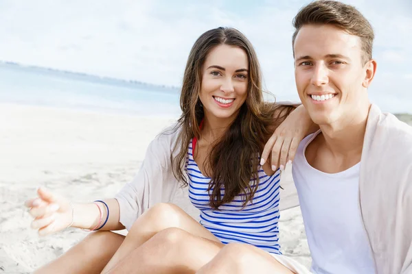 Romántica pareja joven sentada en la playa Imagen de stock