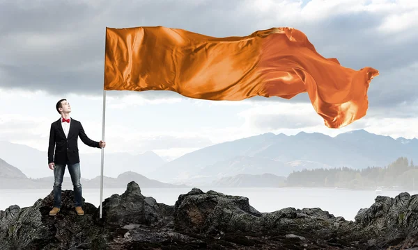 Człowiek z orange macha flagą — Zdjęcie stockowe