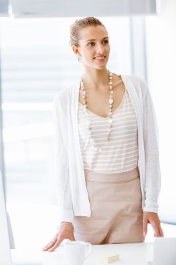 Pencere yanında duran çekici ofis çalışanı