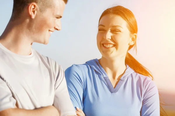 Pareja joven en la playa en ropa deportiva — Foto de Stock