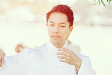 Yakışıklı adam Thai Chi yapıyor.