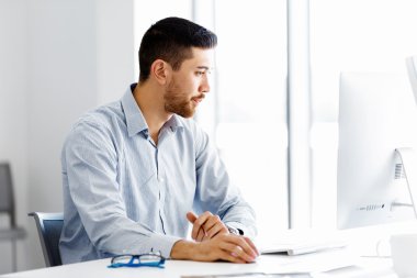 Masa başında oturan erkek ofis çalışanı