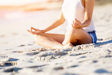 Genç bir kadın sahilde dinleniyor.