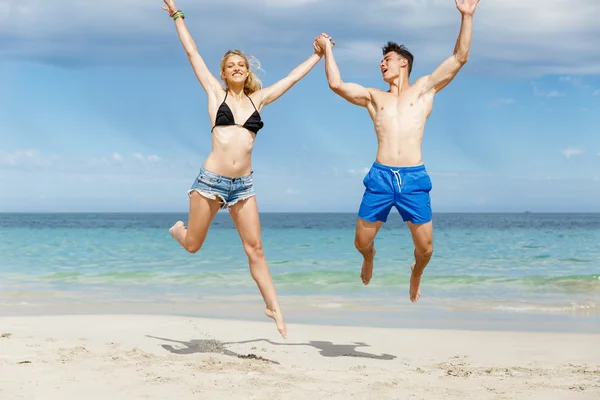 Ευτυχισμένο ζευγάρι άλμα σε παραλία διακοπές — Φωτογραφία Αρχείου