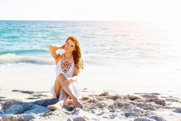 Young woman sitting on the beach — Stock Photo, Image