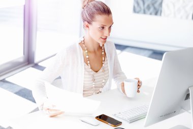 Çekici ofis çalışanı masada oturuyor.