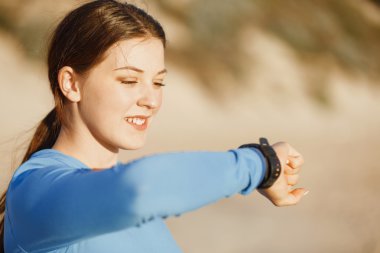 Kalp atış hızı monitörünü plajda çalışan kadınla Runner