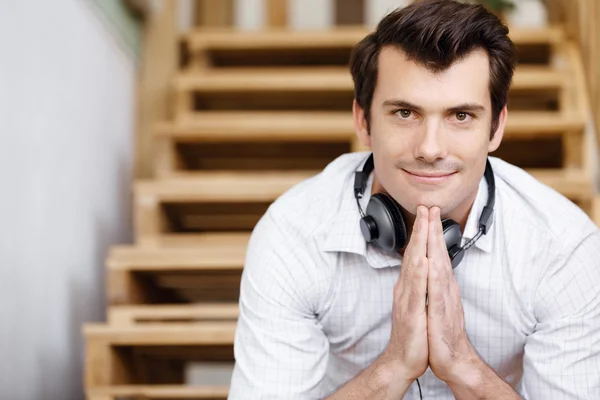 Porträt eines jungen Mannes, der im Büro an der Treppe sitzt — Stockfoto