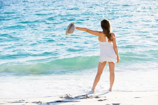 Jovem mulher caminhando ao longo da praia — Fotografia de Stock