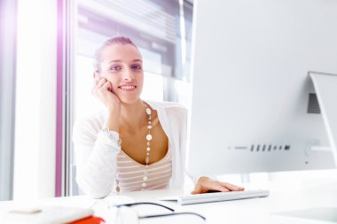 Çekici ofis çalışanı masada oturuyor.