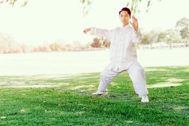 Yakışıklı adam Thai Chi yapıyor.