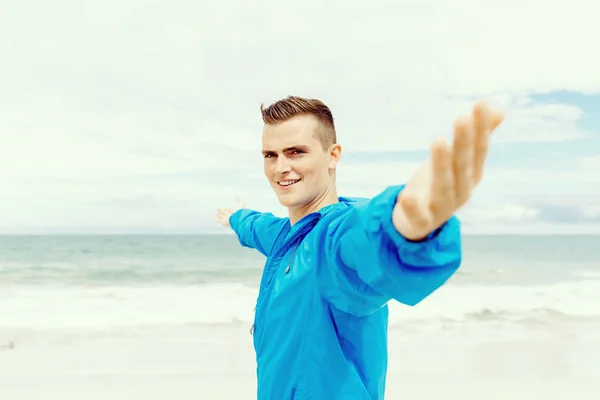 Young man in sport wear with outstretched arms — Stock Photo, Image