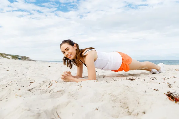 Jonge vrouw opleiding op strand buiten — Stockfoto