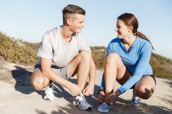 Casal de corredores rendem seus sapatos e se preparam para correr — Fotografia de Stock