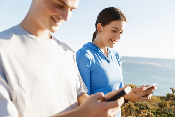 Jong (echt) paar met smartphones outdoors — Stockfoto
