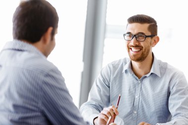 Ofiste iki yakışıklı işadamı var.