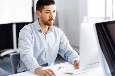 Masa başında oturan erkek ofis çalışanı