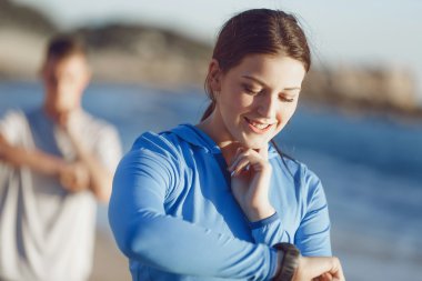 Kalp atış hızı monitörünü plajda çalışan kadınla Runner