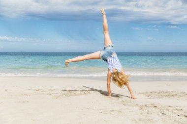 genç kadın kumsalda atlama