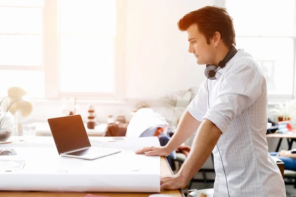 Young man standing in creative office — Stock Photo, Image