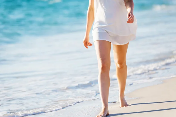 Mujer joven caminando por la playa —  Fotos de Stock