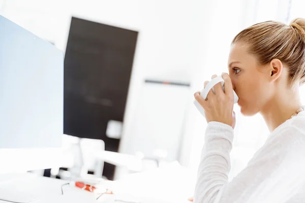 Atraktivní kancelářský pracovník sedící za stolem — Stock fotografie