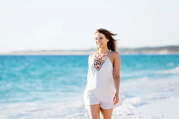 Mladá žena kráčející po pláži — Stock fotografie