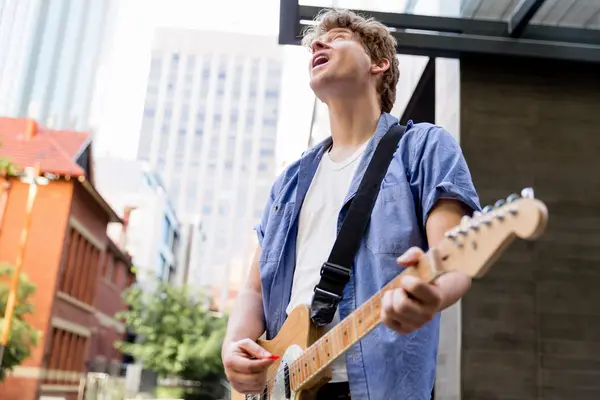 Young musician with guitar in city — Stock Photo, Image