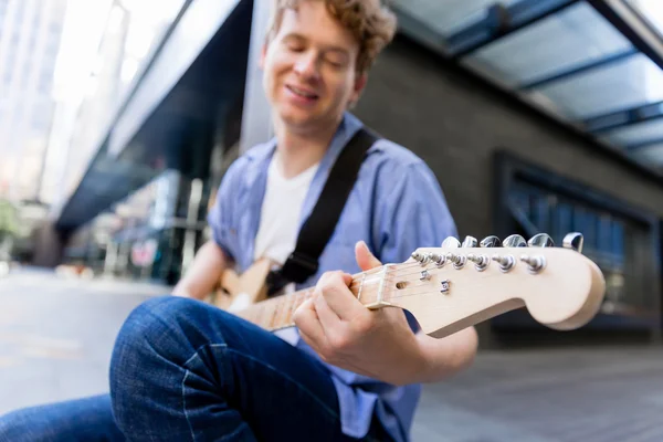 Jovem músico com guitarra na cidade — Fotografia de Stock