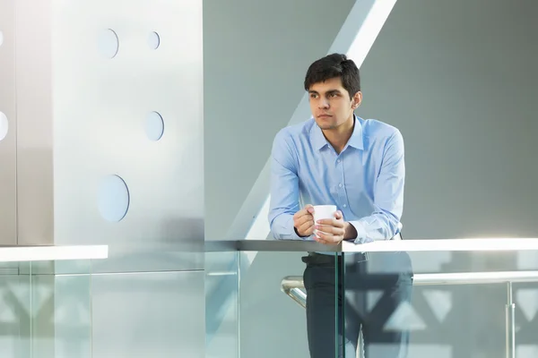 Businessman leaning on balcony railings — Stock Photo, Image