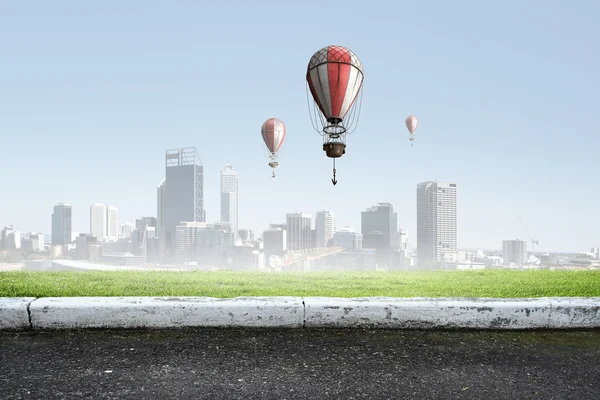 Aerostats flying over city — Stock Photo, Image