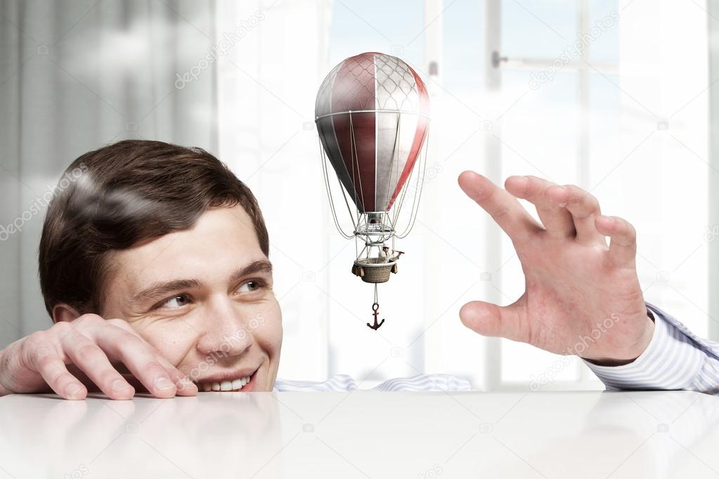 Big businessman peeping from under table