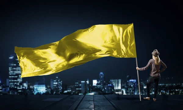 Žena s žlutá mává vlajkou — Stock fotografie