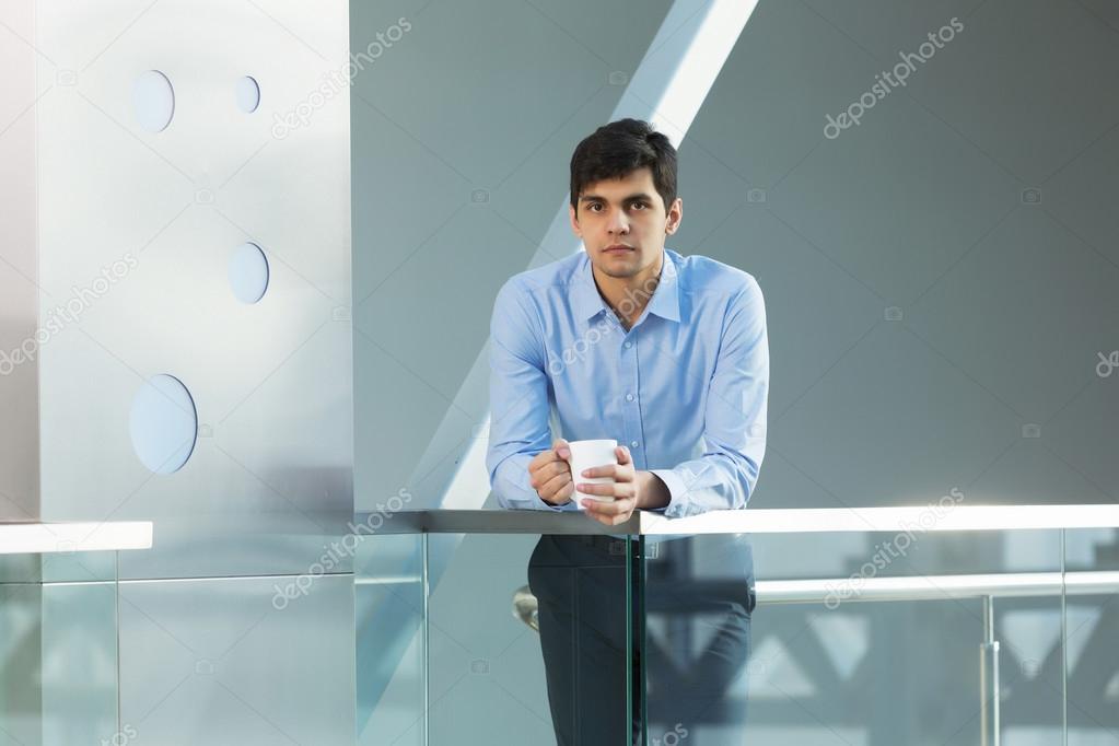 Businessman leaning on balcony railings