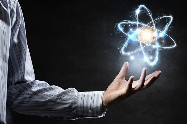 Atomsymbol in der Handfläche — Stockfoto