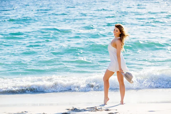 Jovem mulher caminhando ao longo da praia — Fotografia de Stock