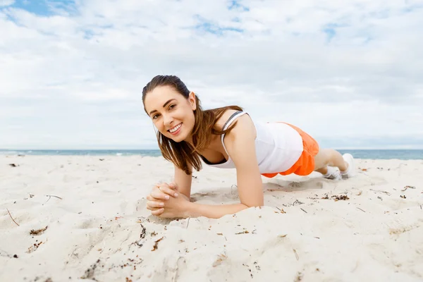 Jonge vrouw opleiding op strand buiten — Stockfoto