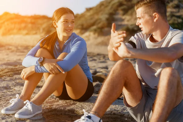 Pareja en ropa deportiva en la playa —  Fotos de Stock