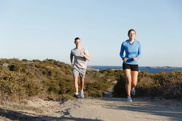 Sport runner joggen op strand uit te werken met haar partner — Stockfoto