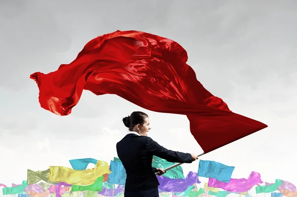 Mujer ondeando bandera roja — Foto de Stock