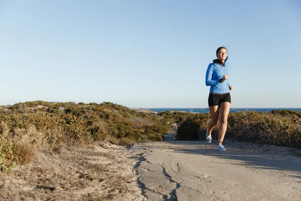Sport runner joggen op strand uit te werken — Stockfoto