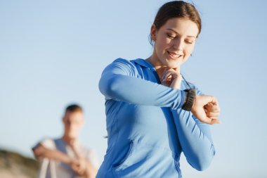 Kalp atış hızı monitörünü plajda çalışan kadınla Runner